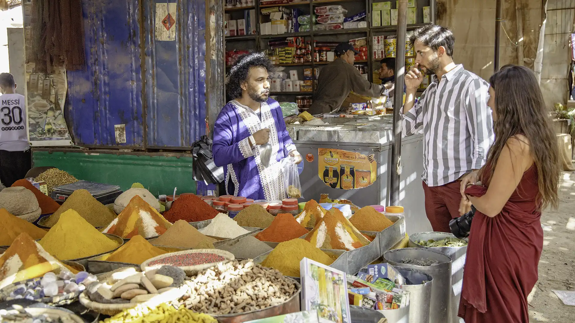 a guide showing to a couple spices Moroccan Souk in Rissani